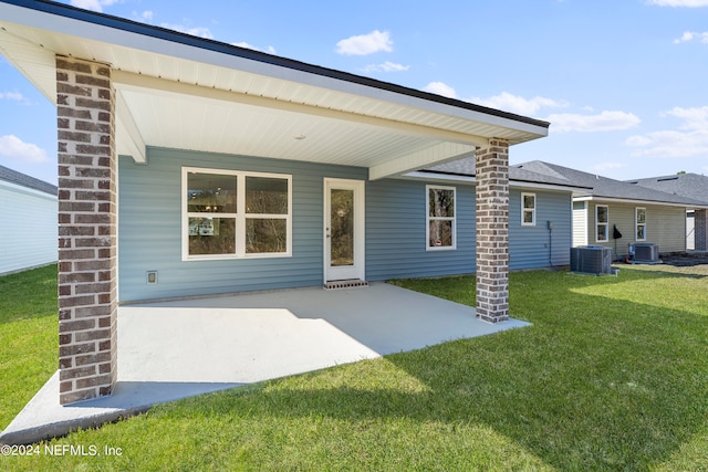 back of property with central AC, a patio, and a lawn