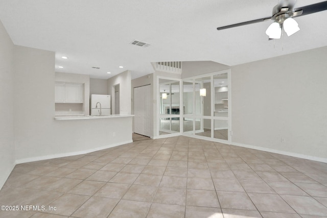 tiled empty room featuring sink and ceiling fan