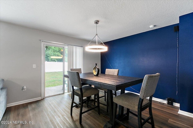 dining area with a textured ceiling and dark hardwood / wood-style floors