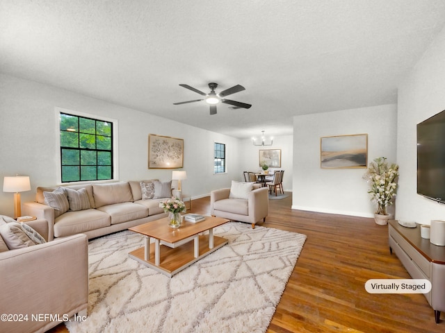 living room with a textured ceiling, hardwood / wood-style flooring, and ceiling fan