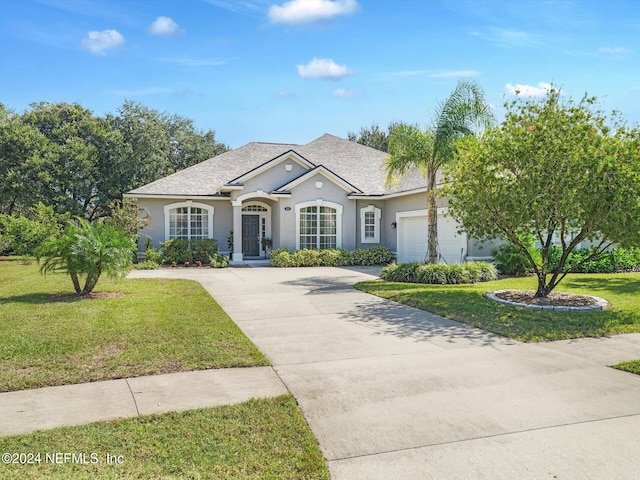 view of front of home with a garage and a front lawn