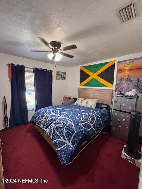 bedroom featuring carpet, a textured ceiling, and ceiling fan