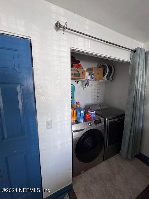 washroom featuring washer and clothes dryer and carpet floors