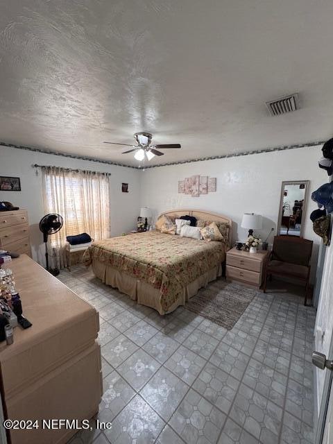 tiled bedroom featuring ceiling fan