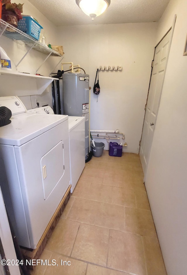 washroom featuring washer and dryer, a textured ceiling, and water heater