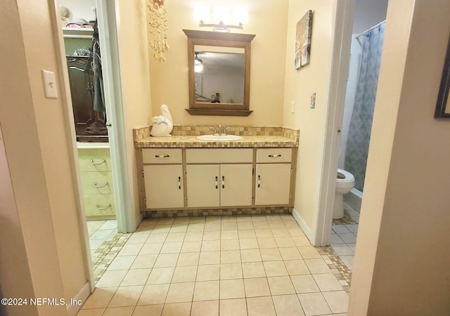 bathroom featuring vanity, toilet, and tile patterned flooring