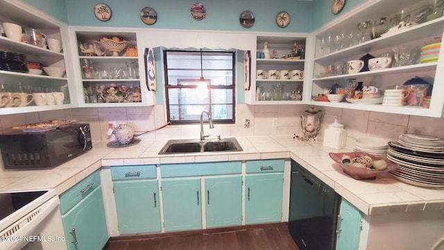 kitchen featuring black appliances, sink, decorative backsplash, and tile counters