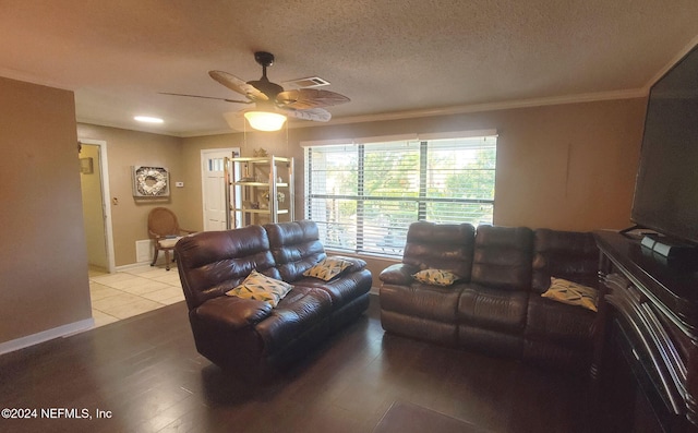 living room with ceiling fan, crown molding, a textured ceiling, and light wood-type flooring