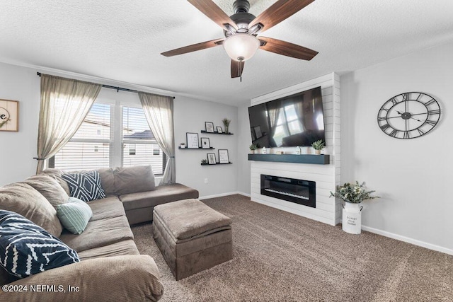 carpeted living room featuring ceiling fan, a large fireplace, and a textured ceiling