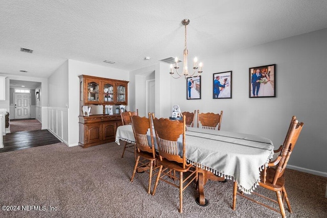 carpeted dining area featuring a textured ceiling and a notable chandelier