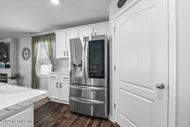 kitchen featuring stainless steel refrigerator with ice dispenser, dark wood-type flooring, a textured ceiling, and white cabinets