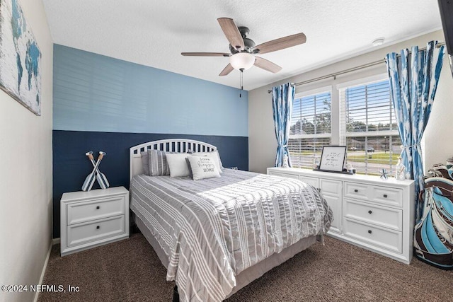 bedroom with ceiling fan, dark carpet, and a textured ceiling