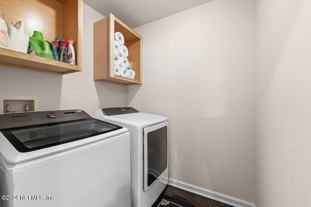 clothes washing area with hardwood / wood-style floors, a textured ceiling, and independent washer and dryer