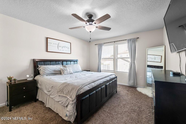 bedroom featuring ceiling fan, a textured ceiling, and dark carpet