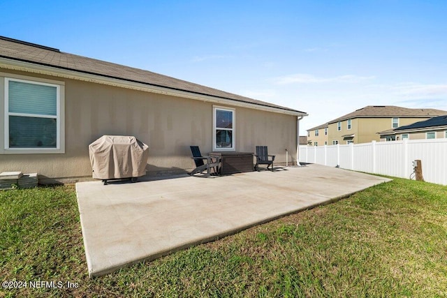 back of property featuring a patio area and a lawn