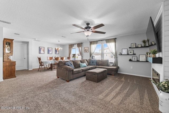 living room featuring dark carpet, a fireplace, a textured ceiling, and ceiling fan with notable chandelier