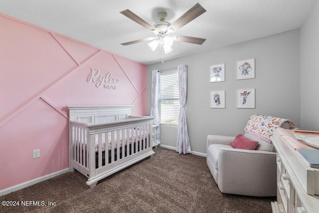 carpeted bedroom featuring ceiling fan, a nursery area, and a textured ceiling