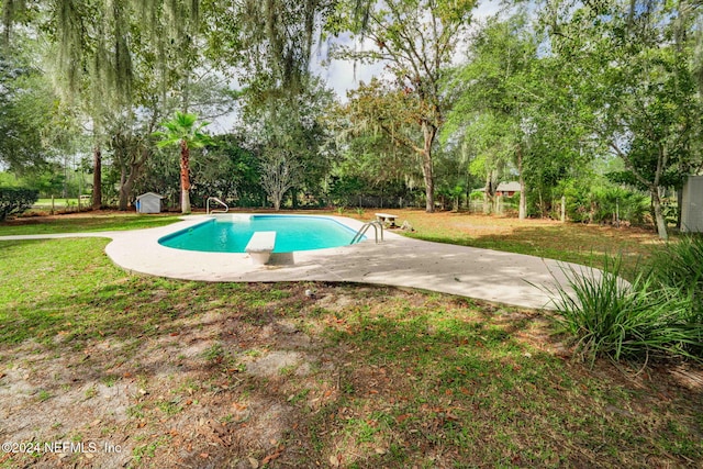 view of pool with a diving board, a patio, and a yard