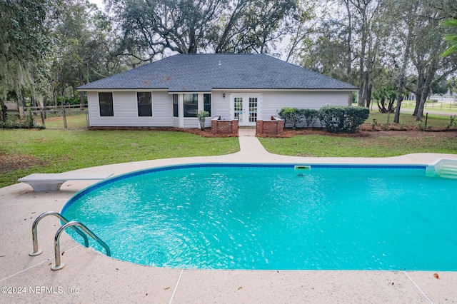 view of pool featuring a lawn and french doors