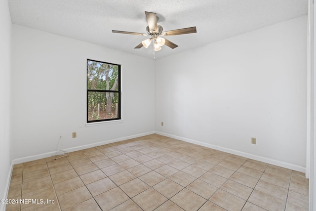 tiled spare room with ceiling fan and a textured ceiling