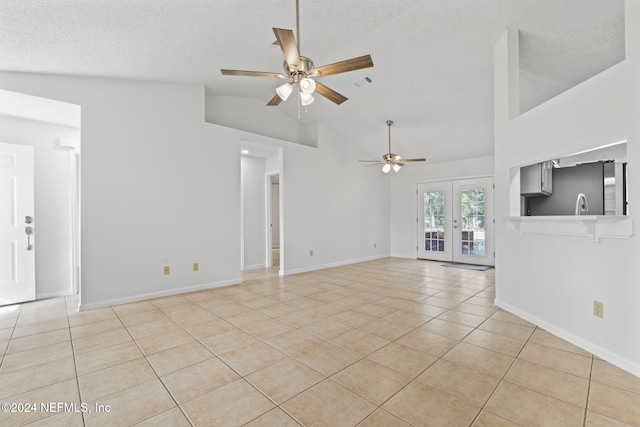 unfurnished living room featuring ceiling fan, a textured ceiling, light tile patterned floors, and french doors