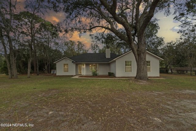 single story home featuring a lawn and a patio area