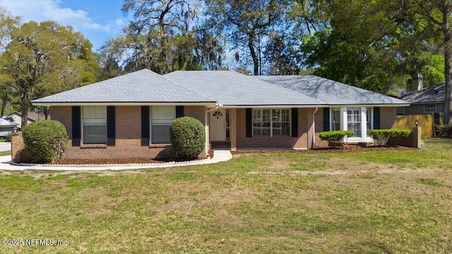 single story home featuring a front lawn, brick siding, and roof with shingles