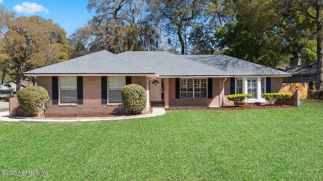 single story home featuring a front yard and brick siding