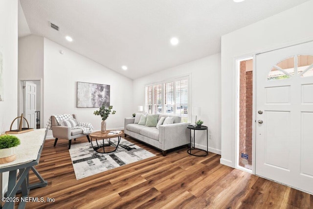 living area featuring lofted ceiling, recessed lighting, wood finished floors, and visible vents