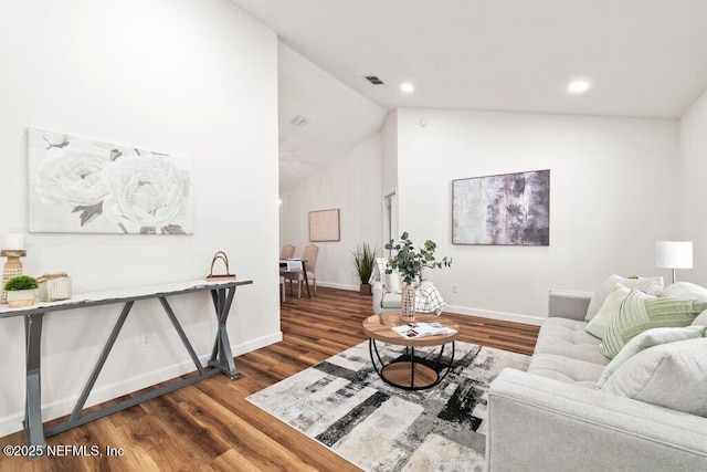 living room featuring visible vents, baseboards, dark wood-style floors, and vaulted ceiling