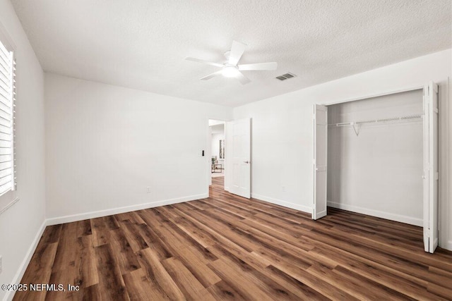 unfurnished bedroom featuring baseboards, ceiling fan, dark wood finished floors, a closet, and a textured ceiling