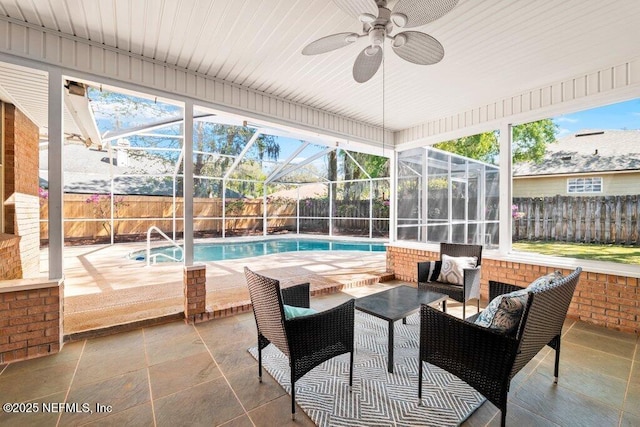 sunroom / solarium with a swimming pool and a ceiling fan