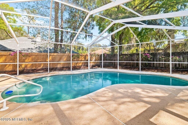 view of swimming pool featuring a lanai, a fenced in pool, a patio, and a fenced backyard