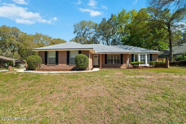 ranch-style house featuring a front lawn and brick siding