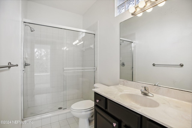 bathroom featuring vanity, toilet, tile patterned flooring, and a shower with door