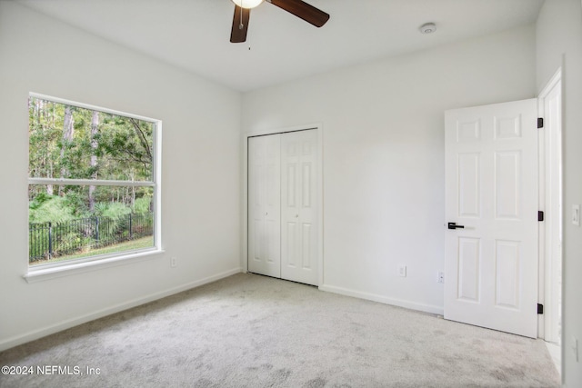 unfurnished bedroom with a closet, light carpet, and ceiling fan