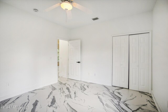 2693 Seneca Dr, Saint Johns, FL 32259 - unfurnished bedroom with baseboards, a closet, light marble finish flooring, and a ceiling fan