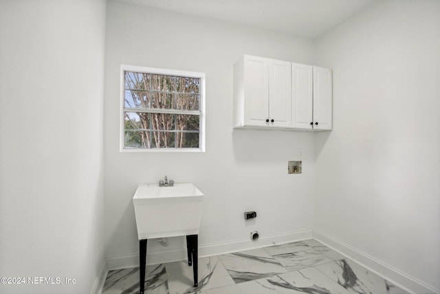 washroom with washer hookup and cabinets