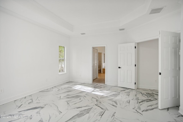 unfurnished bedroom with crown molding and a tray ceiling