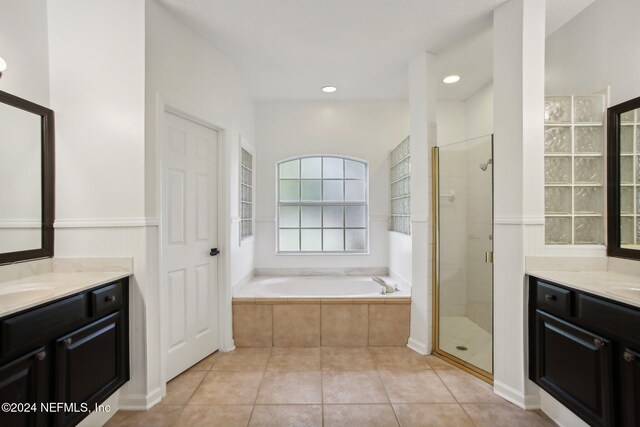 bathroom featuring vanity, shower with separate bathtub, and tile patterned flooring