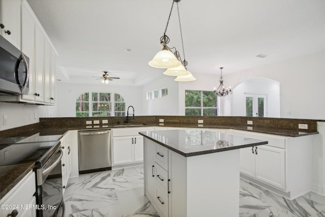 kitchen featuring hanging light fixtures, sink, white cabinetry, appliances with stainless steel finishes, and ceiling fan with notable chandelier