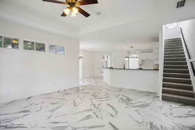 2693 Seneca Dr, Saint Johns, FL 32259 - unfurnished living room featuring a ceiling fan, stairs, a chandelier, and baseboards