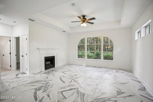 2693 Seneca Dr, Saint Johns, FL 32259 - unfurnished living room with a raised ceiling, ceiling fan, baseboards, a fireplace, and marble look tiles