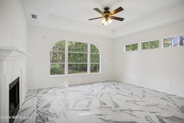 unfurnished bedroom with a tray ceiling and ceiling fan