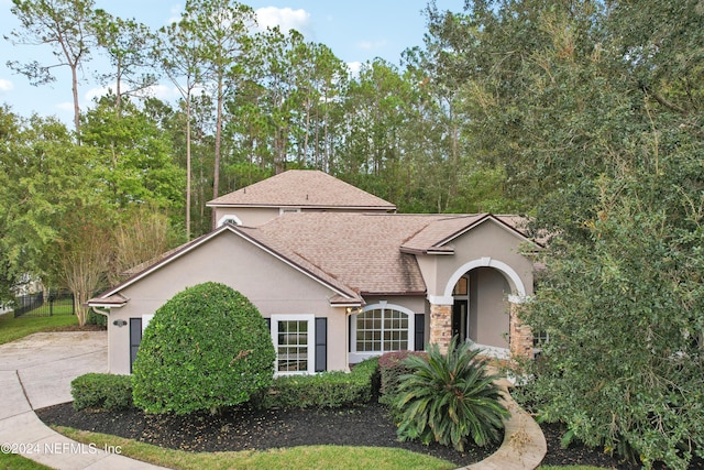2693 Seneca Dr, Saint Johns, FL 32259 - view of front of property featuring stucco siding, driveway, stone siding, and a shingled roof