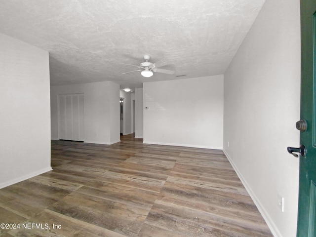 spare room featuring ceiling fan, wood finished floors, baseboards, and a textured ceiling