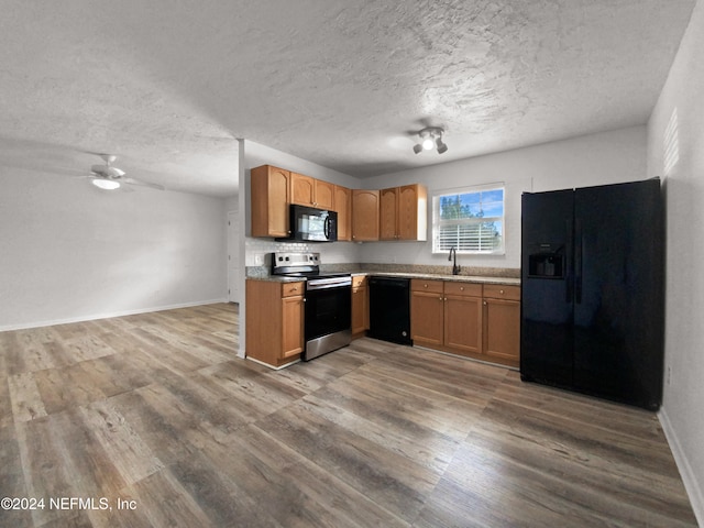 kitchen with black appliances, sink, wood-type flooring, a textured ceiling, and ceiling fan