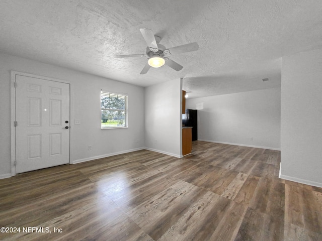 unfurnished living room with ceiling fan, a textured ceiling, and dark hardwood / wood-style flooring