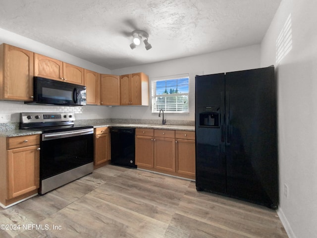 kitchen with black appliances, sink, a textured ceiling, light hardwood / wood-style floors, and decorative backsplash