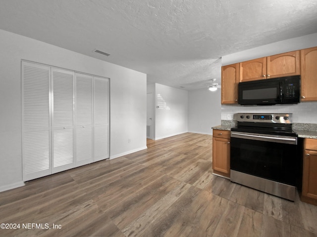 kitchen with a textured ceiling, wood-type flooring, stainless steel electric range oven, and ceiling fan